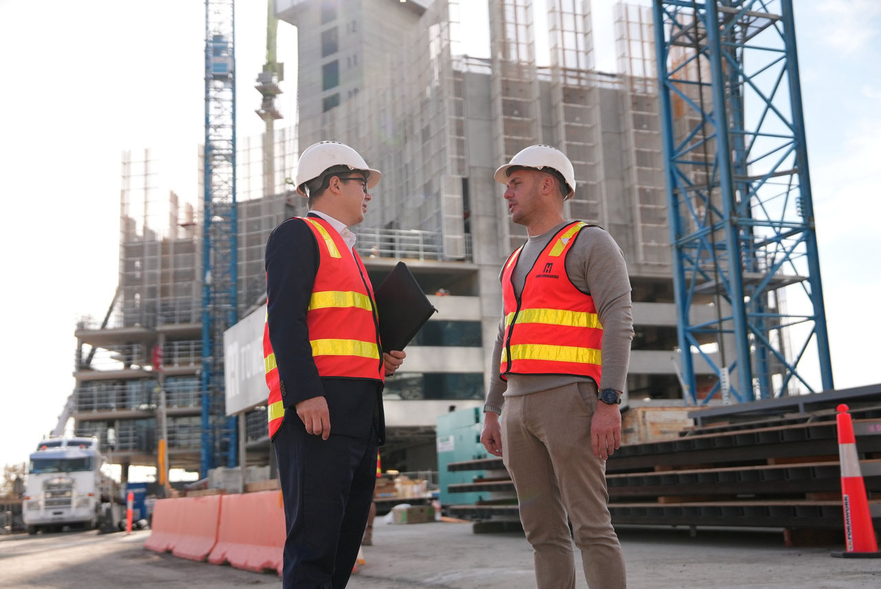 two men on a construction site in front of a large battery