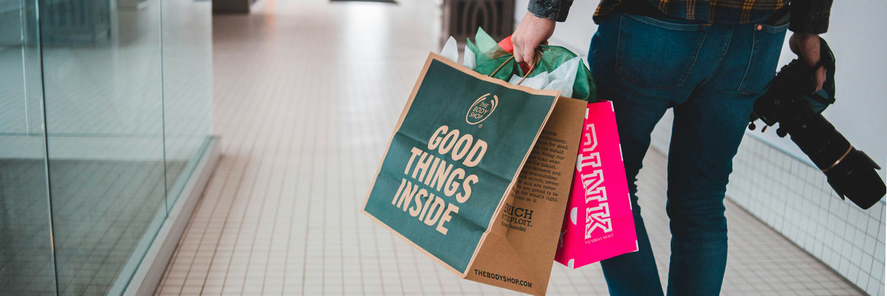 Consumer carrying several large shopping bags