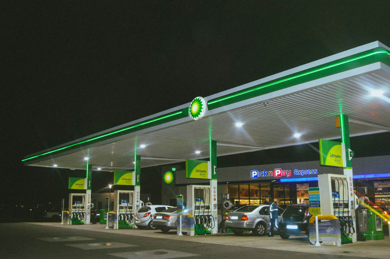 BP petrol station with cars filling up at bouser in the evening