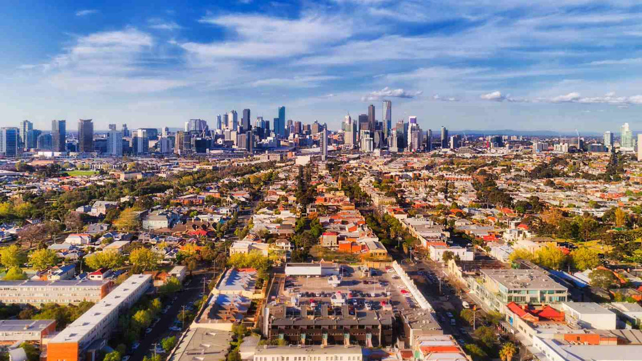 Aerial view of houses in suburbs with a cityscape in the background