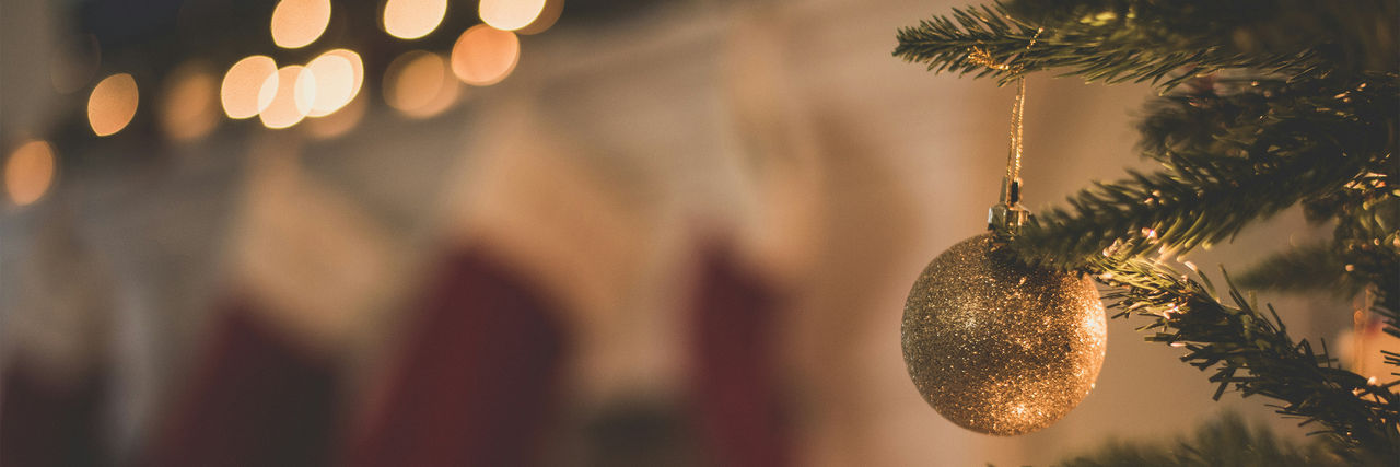 Gold bauble hanging on Christmas tree