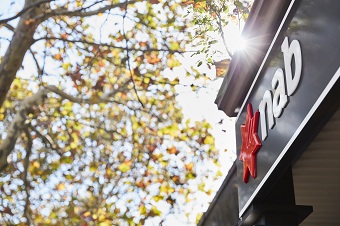 NAB logo on building next to tree