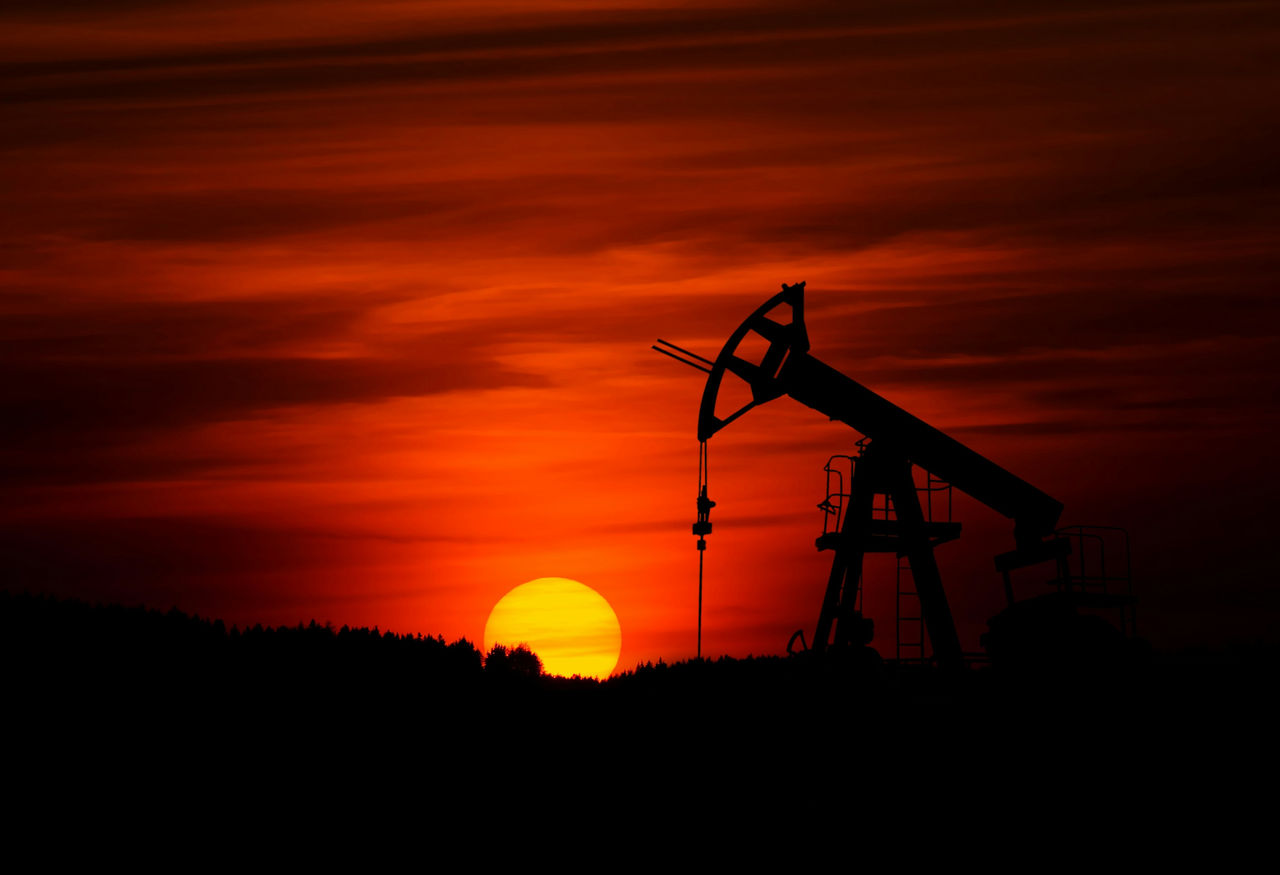 red sunset behind oil field site