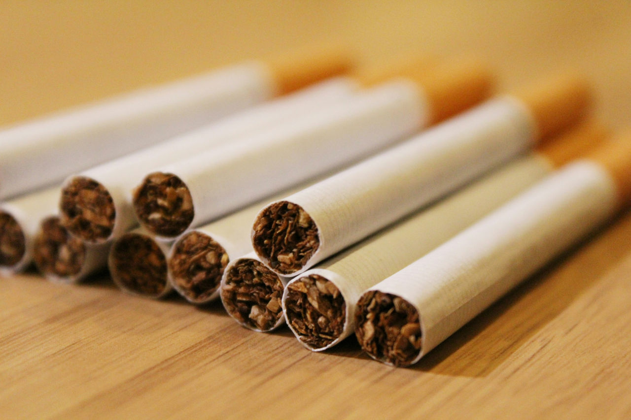 pile of cigarettes on wooden table