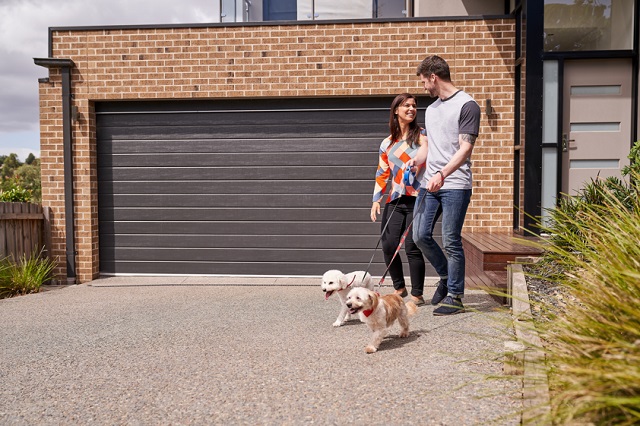 Couple and two dogs in front of a house
