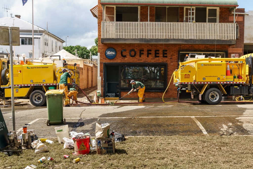 Emergency services workers and trucks cleaning up after a flood.
