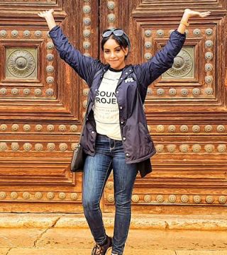 A woman, Alaa Karrar, with her hands in the air