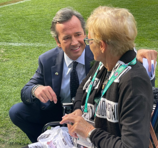 Woman in a wheelchair talking to a man on the MCG.