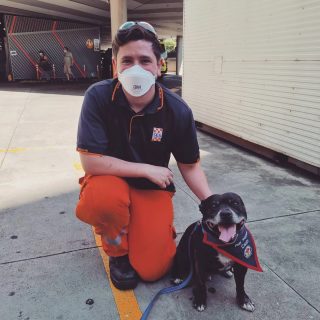 man in SES uniform smiling with dog