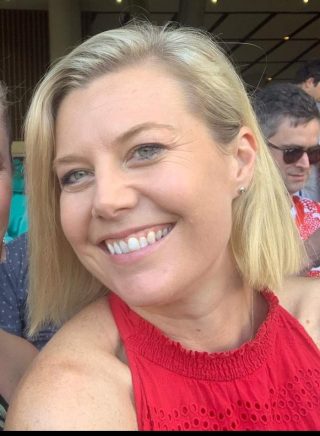 Picture of a woman in a red top smiling.