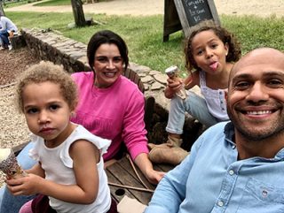 Brian Wyborn relaxing in a park with his wife and two young children