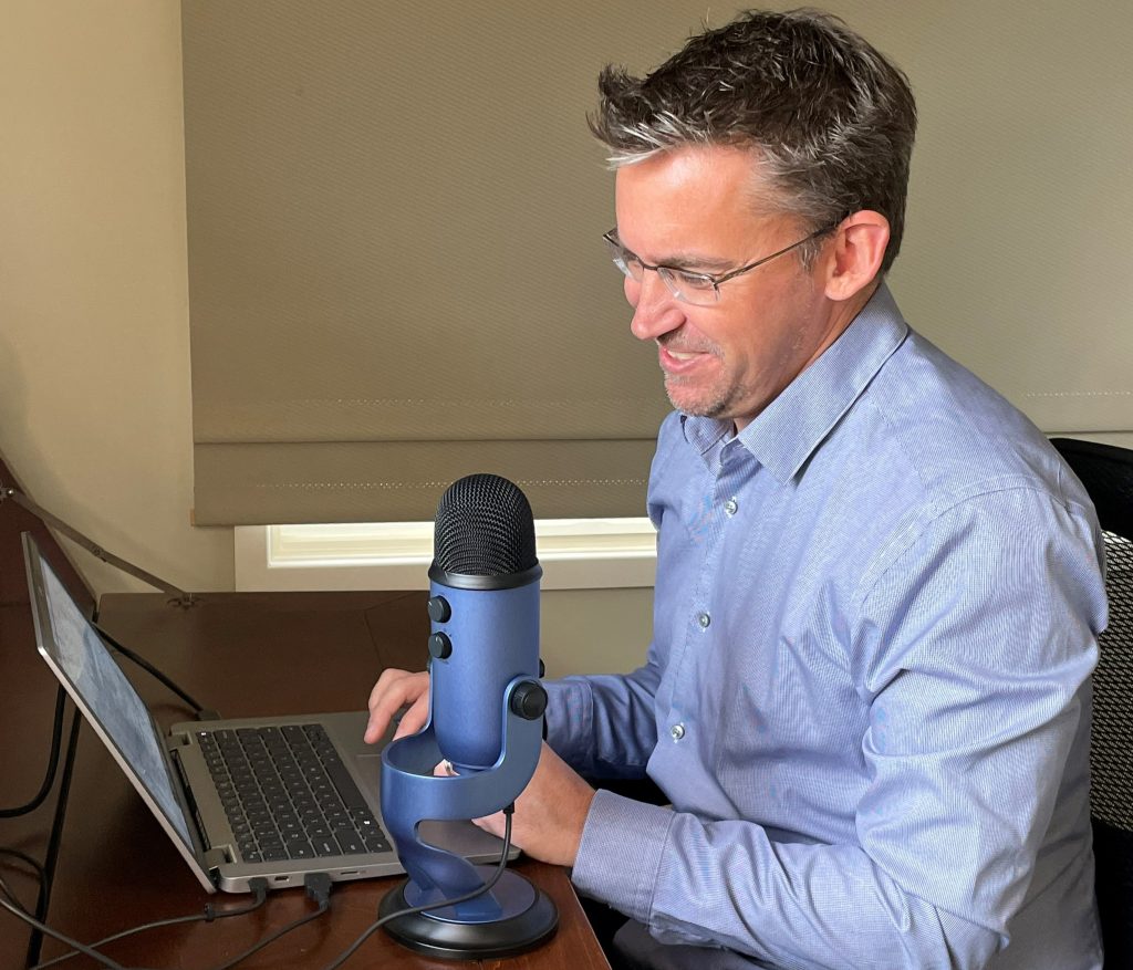 Man smiling while using microphone