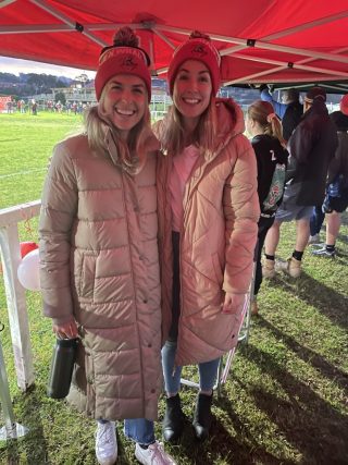 Sophie at the footy wearing her team's beanie 