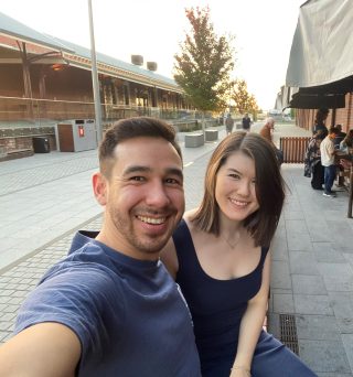 Young couple take selfie out front of train station