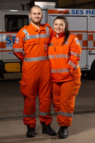 A couple (Thea and her husband Tay) in orange SES uniform smiling for camera