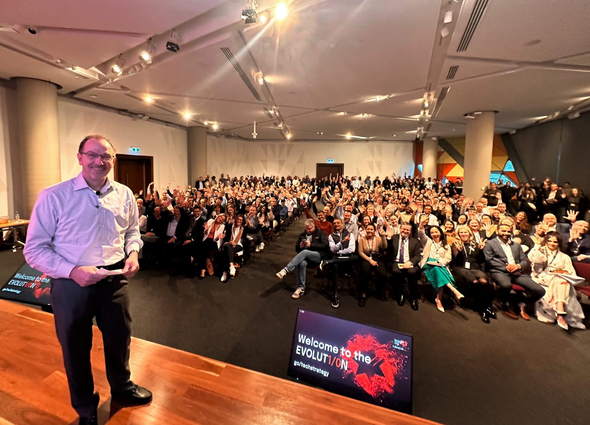 Patrick Wright on stage in front of NAB colleagues waving