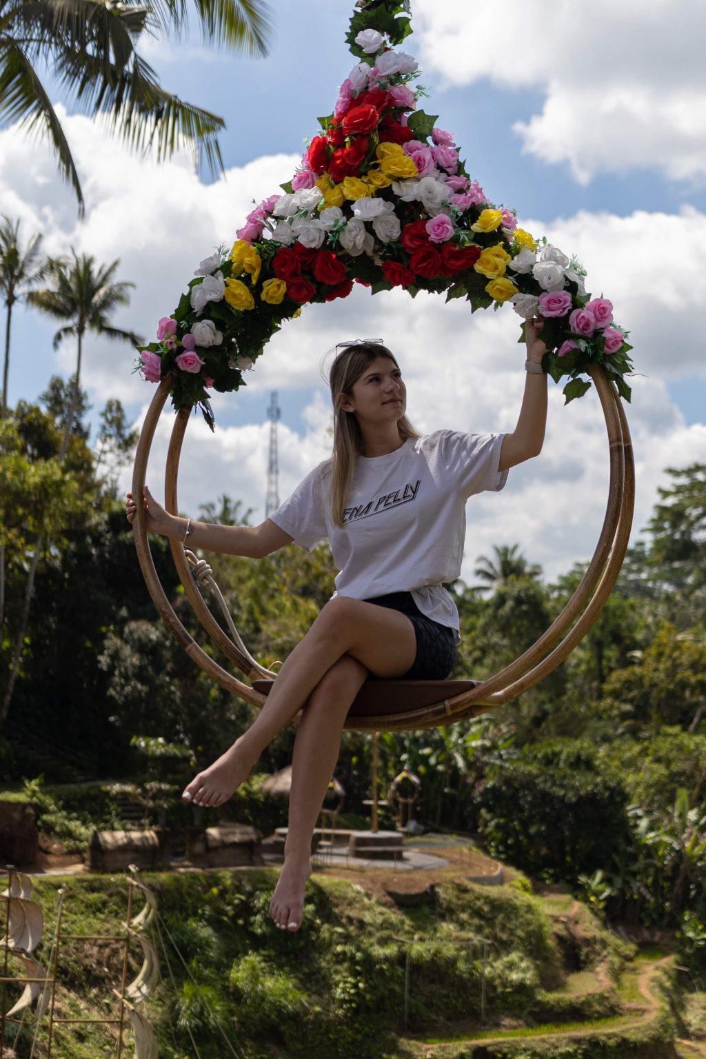 Photograph of a woman sitting on a flower swing in Bali, Indonesia