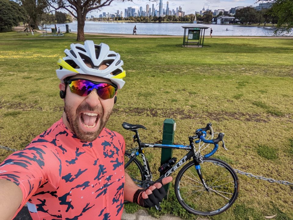 NAB banker Luca in his lycra and helmet, in a park in front of his bike