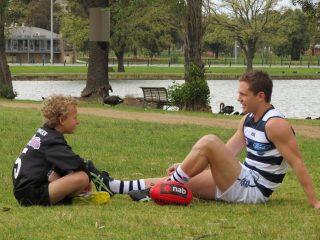 Jedd Busslinger as a child sitting in a park with Joel Selwood