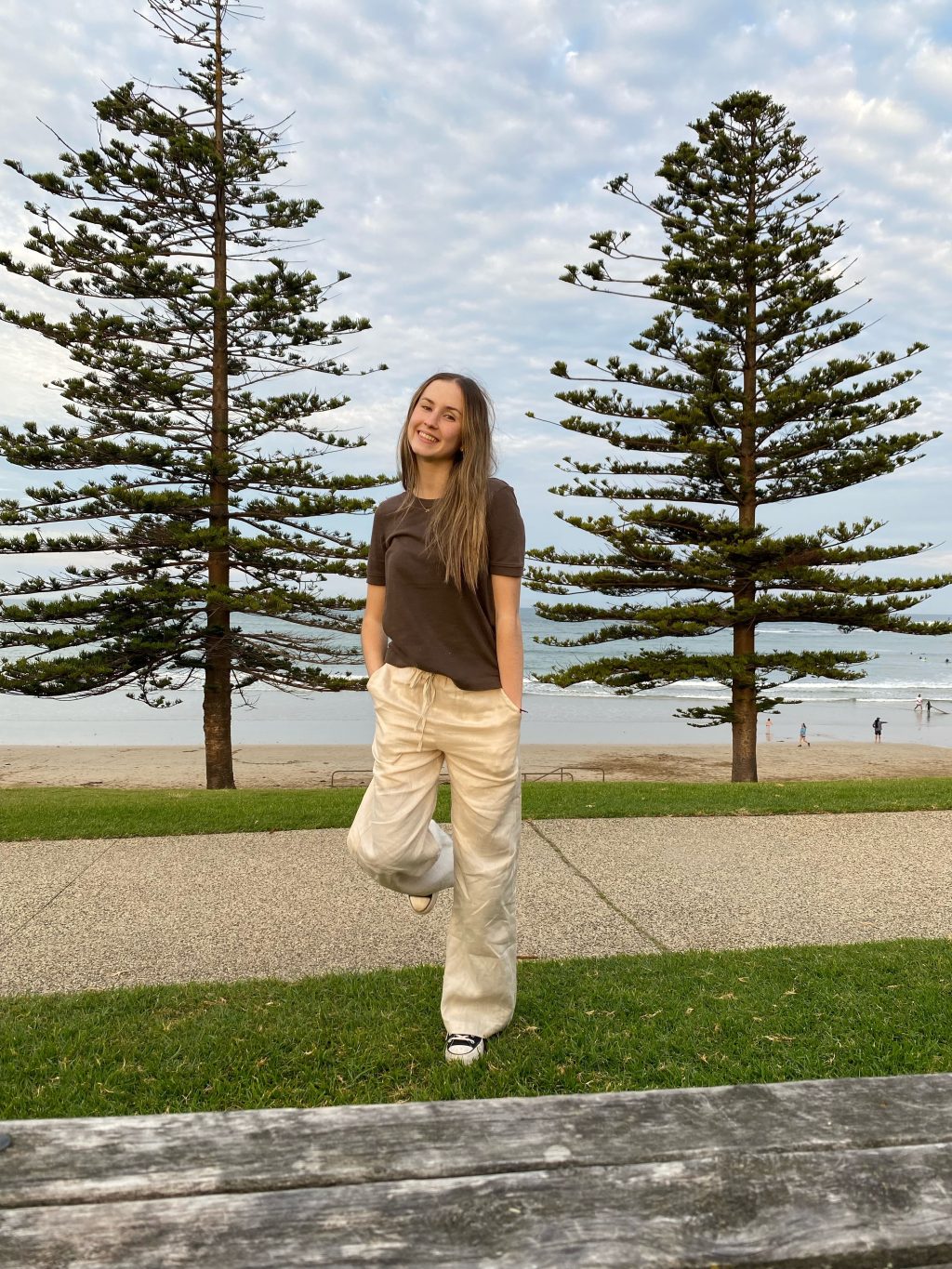 Customer Maya McIntyre standing on a ledge next to a beach.