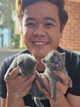 NAB colleague Iqbal holding two neonatal cats