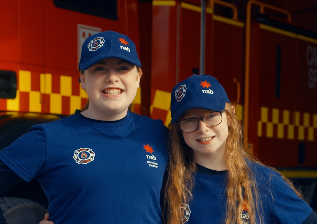 Two Girls on Fire participants standing in front of a fire truck.