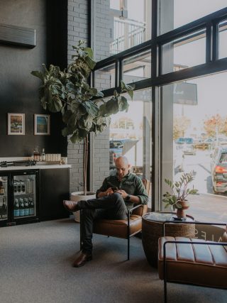 Man sitting in chair looking at mobile phone in office