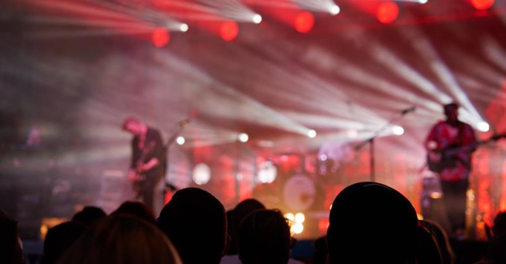 A blurred image of people watching a concert