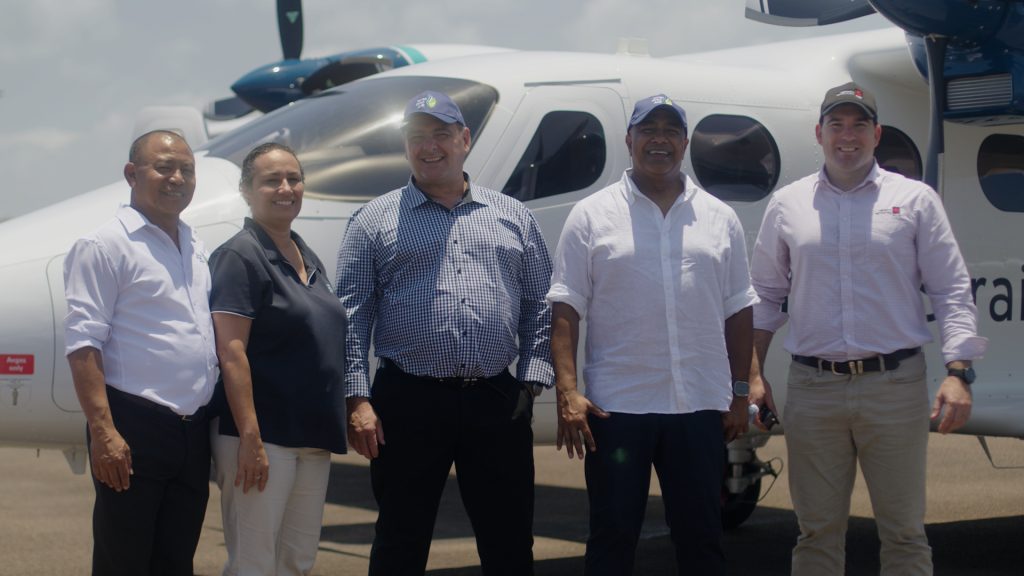 Torres Strait Air founder, Daniel Takai and NAB Head Of Indigenous Business, Noel Prakash stand with others in front of a new aircraft