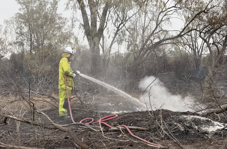 Firefighter with hose in aftermath of Dirranbandi bushfires