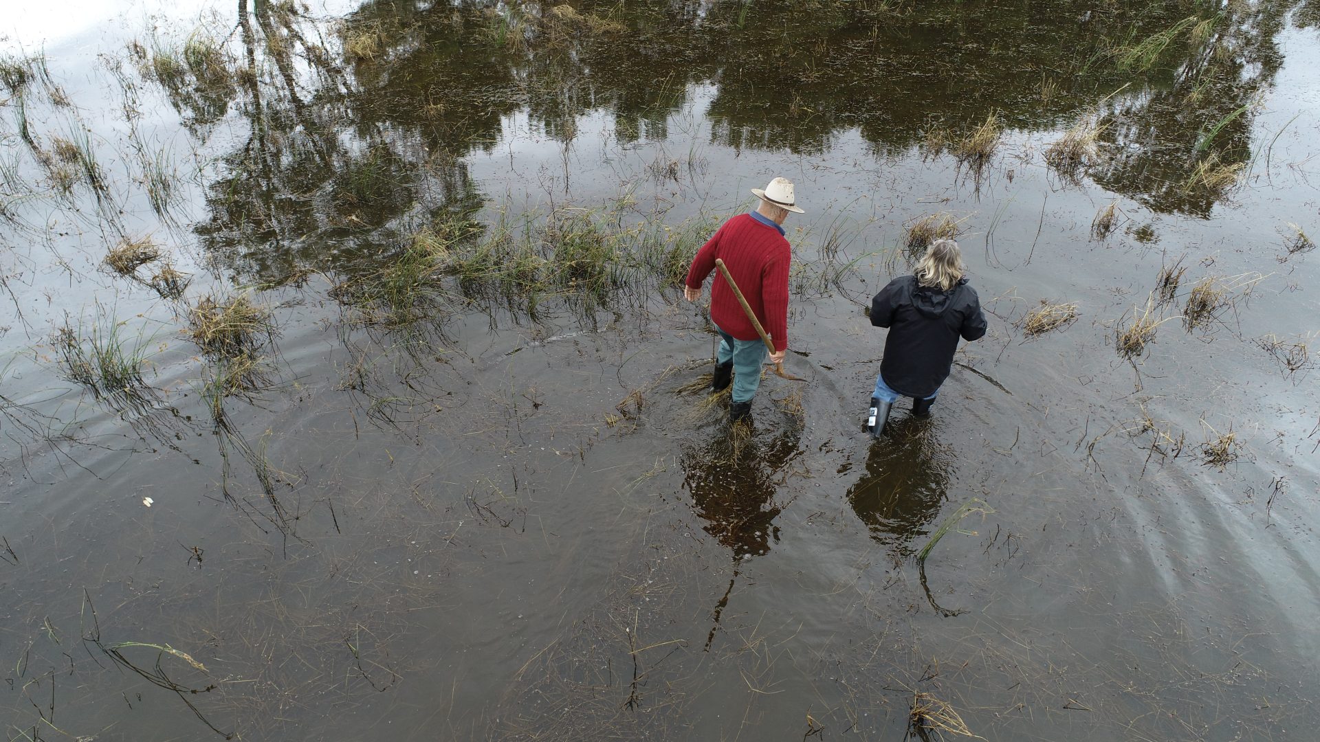 Two people walking through flood water