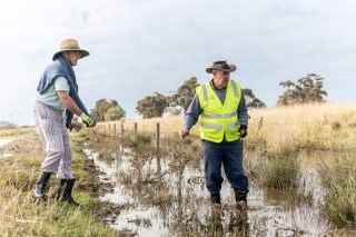 Two people assessing flood water levels