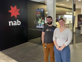 couple standing in front of bank branch 