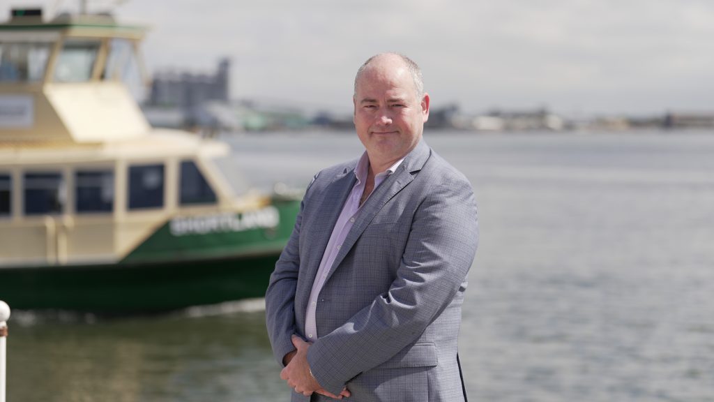 Man standing in front of port with boat in background